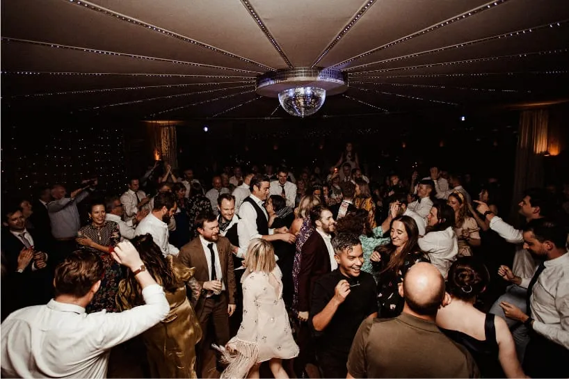 Wedding guests dancing under a mirror ball.